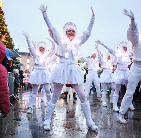 noel-a-chartres-2025-28 Les animateurs de Noël dansent devant des enfants dans une rue à Chartres.