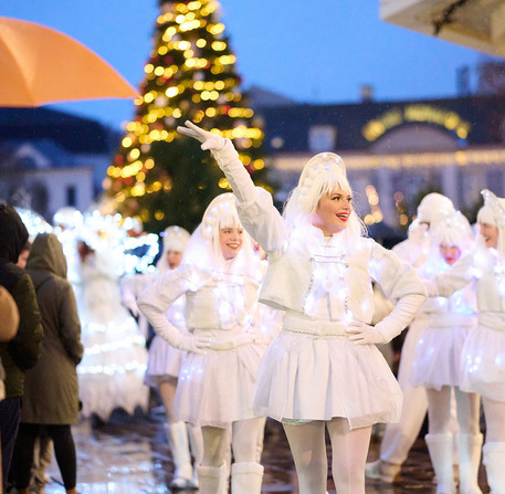 noel-a-chartres-2025-31 Les animateurs de Noël dansent dans une rue de Chartres, devant le sapin.