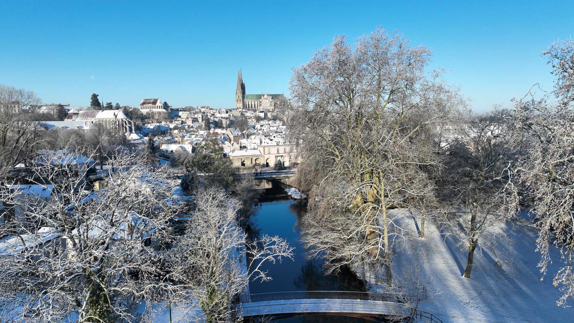Même en hiver, votre jardin continue de vivre Le parc des Bords de l'Eure sous la neige, avec la cathédrale de Chartres en fond