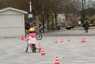 Jeunes cyclistes slalomant entre des plots au village prévention routière