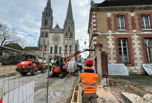 Ouvriers en train de démolir un mur avec des engins de chantier à proximité de la cathédrale de Chartres