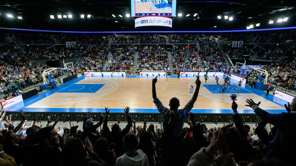 Un match de basket ball au Colisée, avec les supporters debout pour encourager le C'Chartres basket féminin