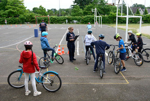 Des écoliers à vélo réalisant un parcours d'obstacle