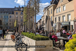 Les habitants et clients flânent dans le centre-ville piétonnier de Chartres et profitent de belles terrasses.