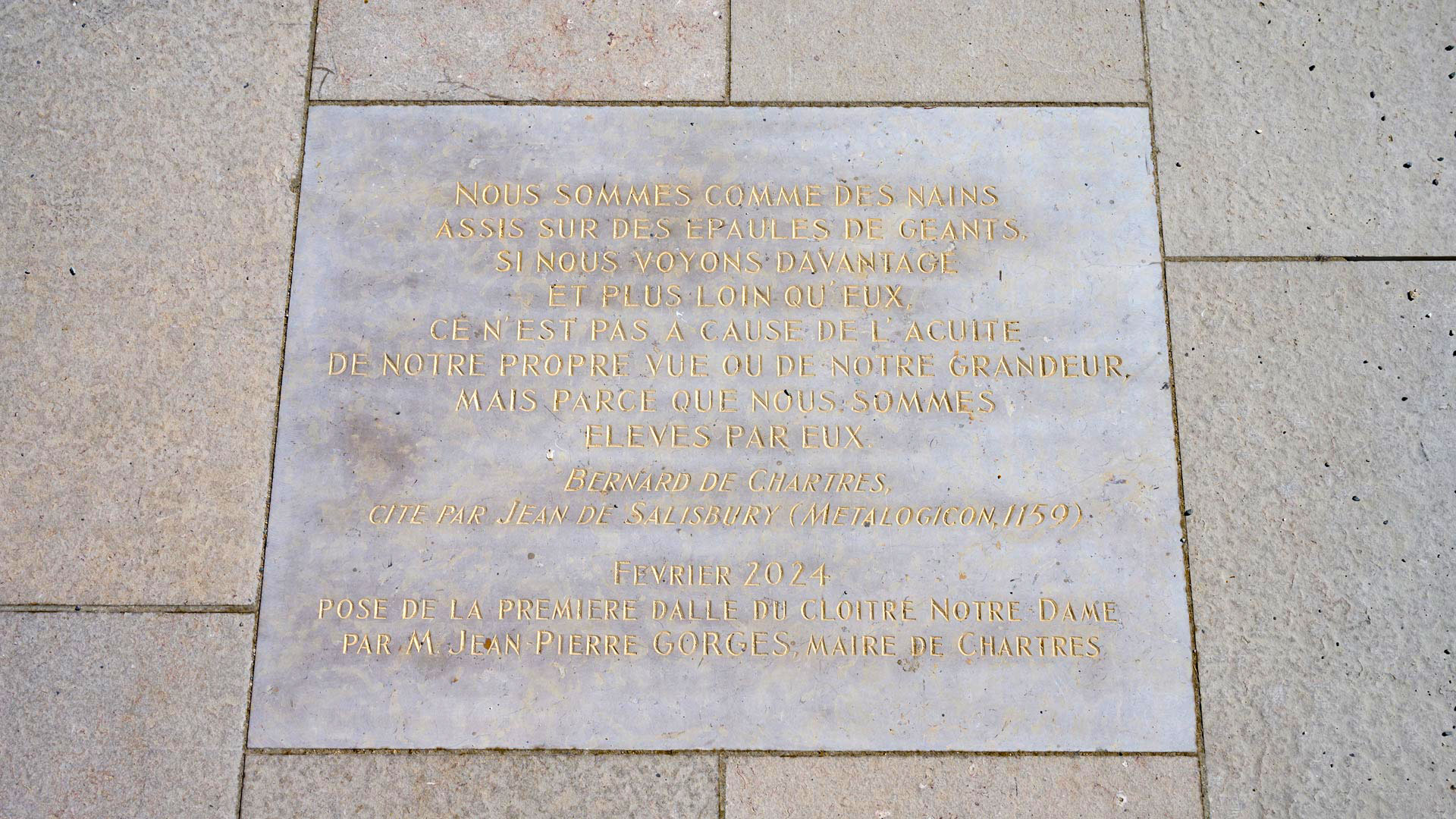 Une dalle de pierre marquée d'une citation scellée devant l'entrée de la cathédrale de Chartres