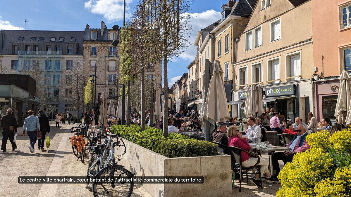 Les habitants et clients flânent dans le centre-ville piétonnier de Chartres et profitent de belles terrasses.