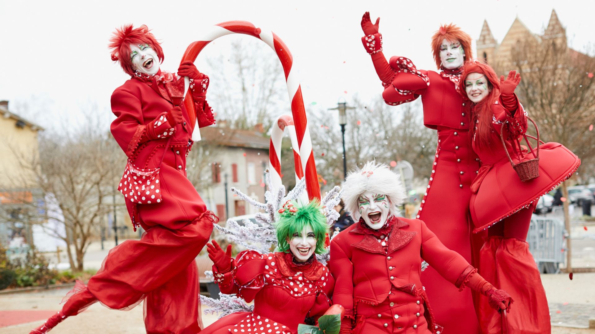 Personnages et échassiers rouges et blancs en parade de Noël