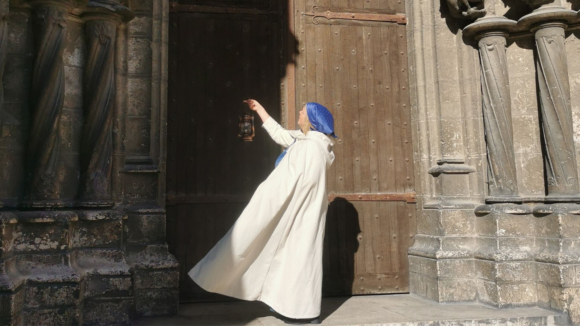 Une conteuse avec une lanterne devant la cathédrale de Chartres